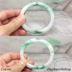 White base with green splotches oval jade bangle