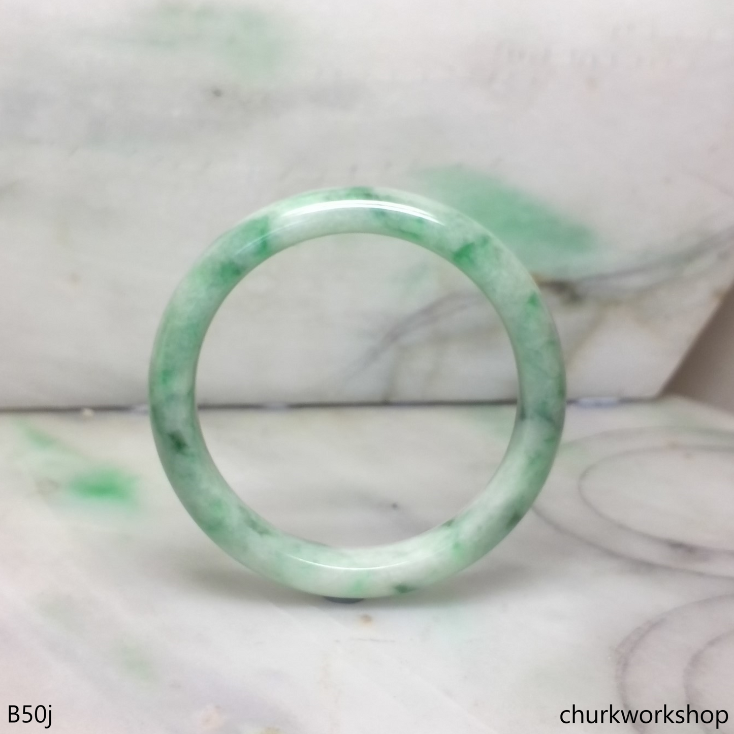Small white base with splotches green jade bangle